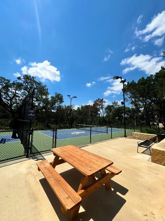 view of home's community featuring tennis court