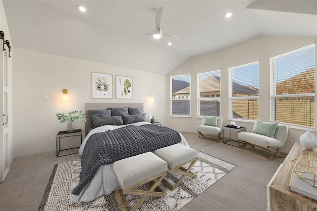 bedroom featuring lofted ceiling, a barn door, and light carpet