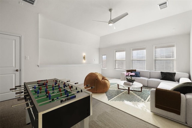 playroom with ceiling fan, vaulted ceiling, carpet, and a tray ceiling