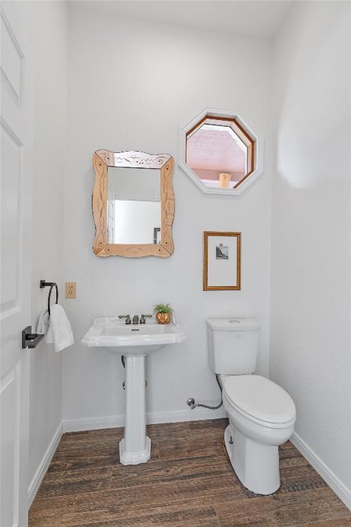 bathroom featuring hardwood / wood-style flooring and toilet