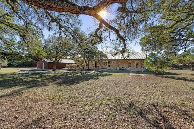 view of yard with a garage and an outbuilding