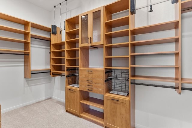 walk in closet featuring light colored carpet