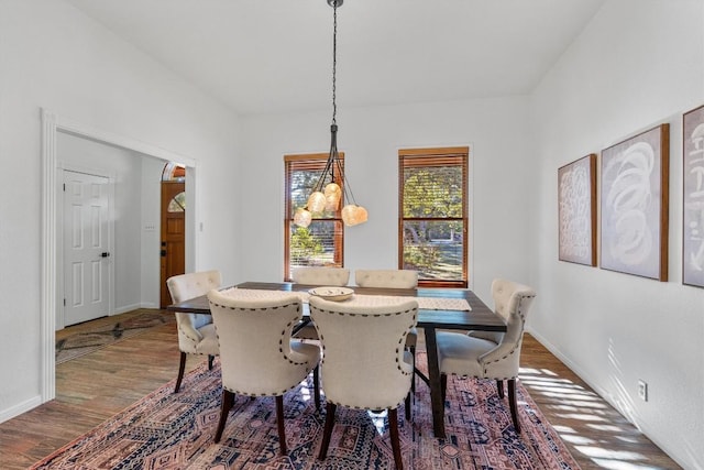 dining room with hardwood / wood-style floors and an inviting chandelier