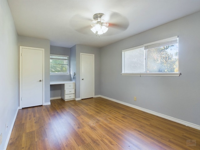 unfurnished bedroom with ceiling fan and dark hardwood / wood-style flooring