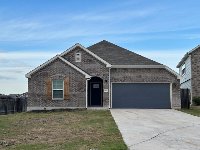 view of front of property with a front yard and a garage