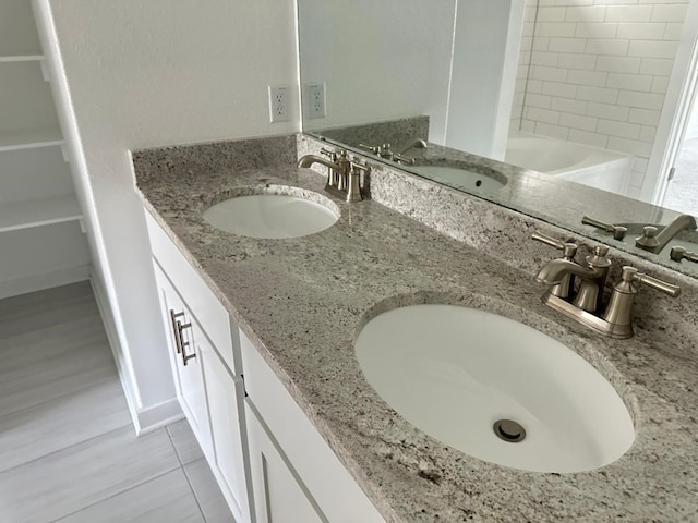 bathroom with tile patterned floors, vanity, and tiled shower / bath