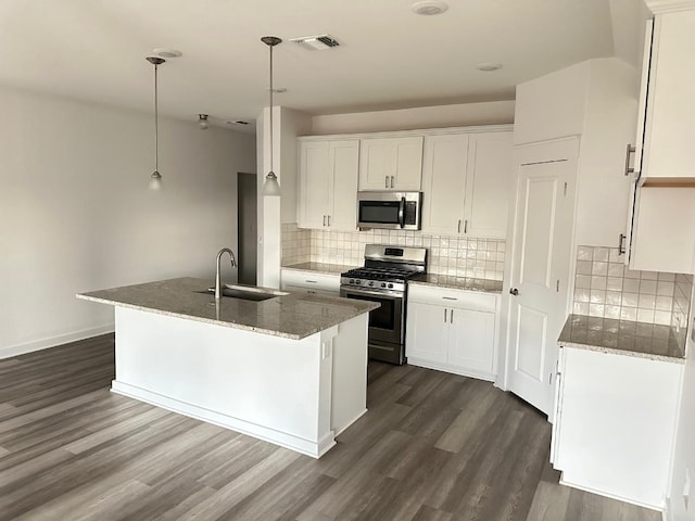 kitchen featuring stainless steel appliances, dark wood-type flooring, sink, white cabinets, and hanging light fixtures