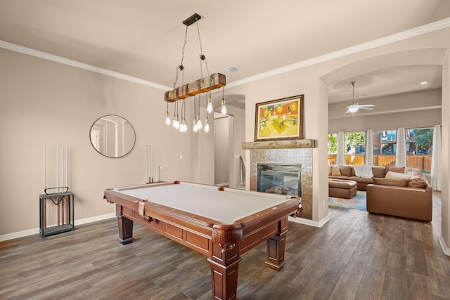 rec room with ornamental molding, ceiling fan, pool table, dark hardwood / wood-style floors, and a tiled fireplace