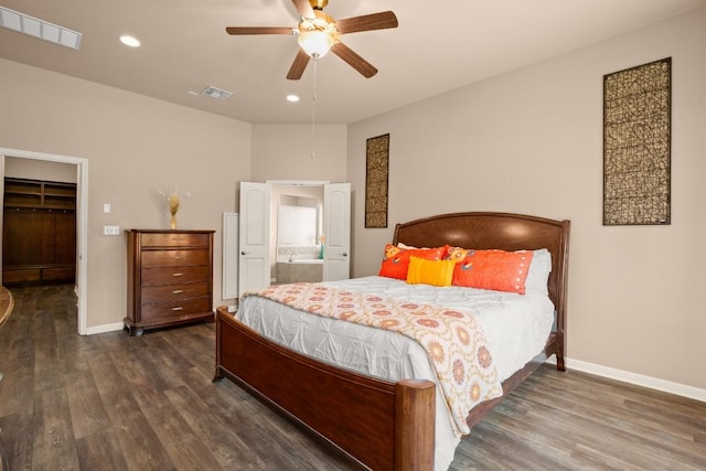 bedroom featuring ceiling fan, dark hardwood / wood-style floors, ensuite bathroom, a walk in closet, and a closet