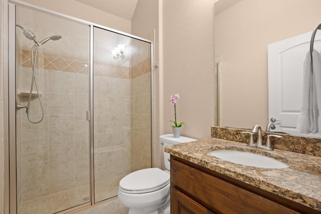 bathroom with vanity, toilet, and a shower with door