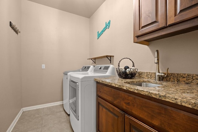 laundry area with separate washer and dryer, sink, light tile patterned floors, and cabinets