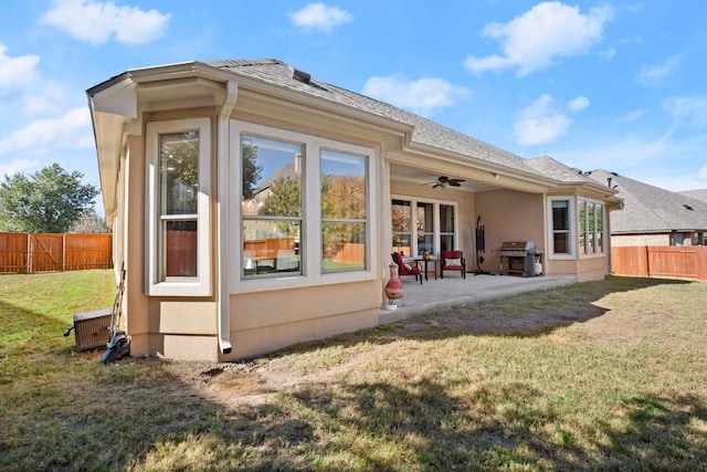 rear view of property with a yard, ceiling fan, and a patio area