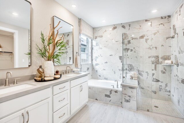 bathroom featuring vanity, wood-type flooring, and plus walk in shower