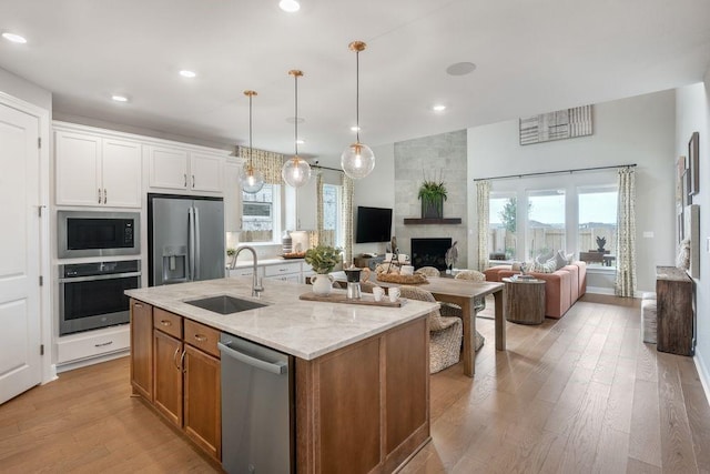 kitchen featuring stainless steel appliances, white cabinetry, a wealth of natural light, and sink