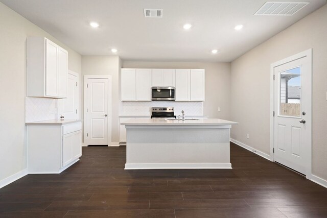 kitchen featuring appliances with stainless steel finishes, tasteful backsplash, dark wood-style floors, and recessed lighting