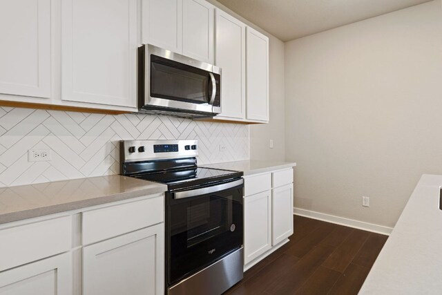 kitchen with appliances with stainless steel finishes, dark wood-type flooring, baseboards, light countertops, and white cabinets