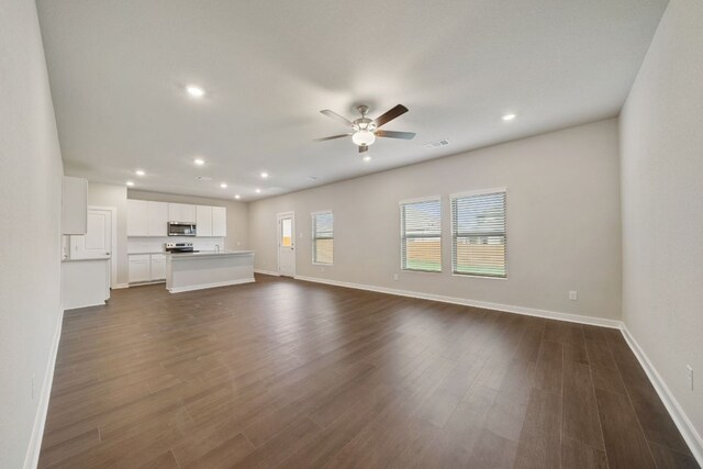unfurnished living room featuring a ceiling fan, baseboards, recessed lighting, and dark wood finished floors