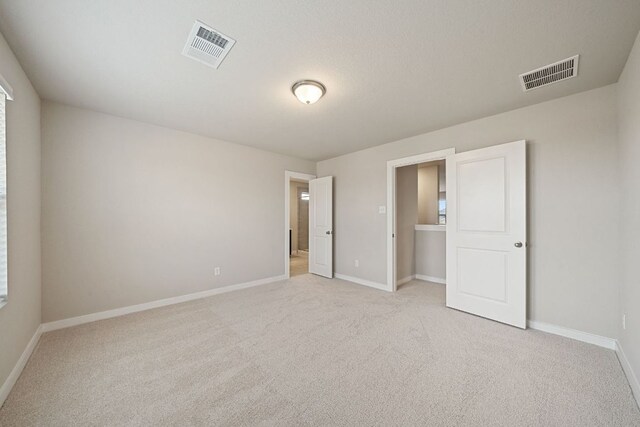 unfurnished bedroom featuring light colored carpet and baseboards