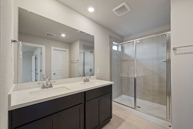 full bathroom featuring a stall shower, double vanity, tile patterned floors, and recessed lighting