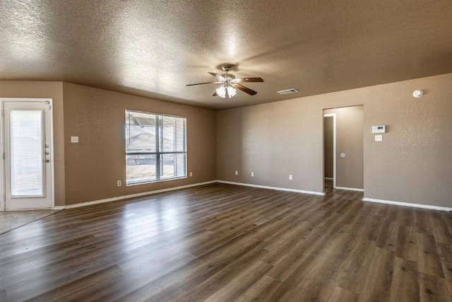 unfurnished living room featuring ceiling fan, dark hardwood / wood-style flooring, and a textured ceiling