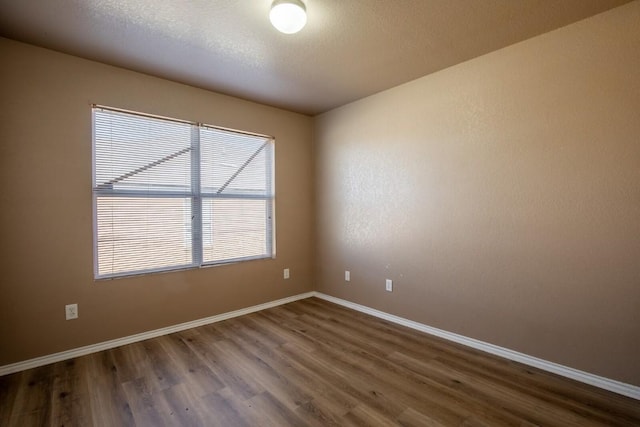 spare room with dark hardwood / wood-style floors