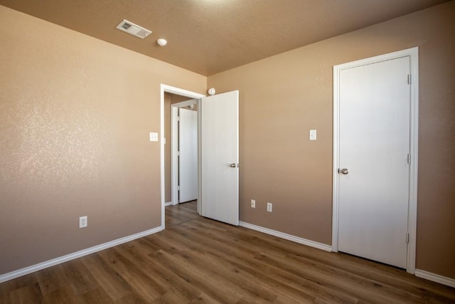 unfurnished bedroom featuring dark hardwood / wood-style flooring