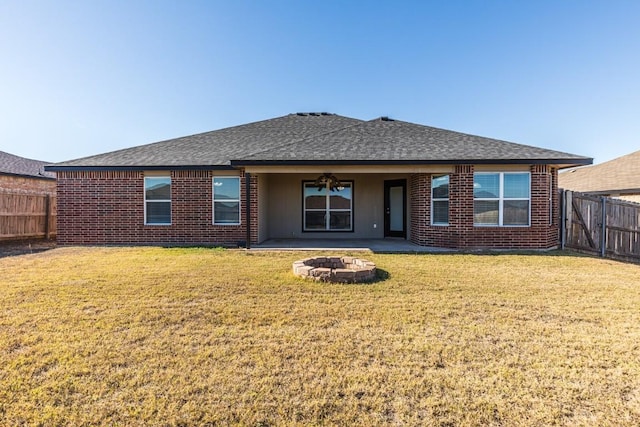 rear view of house with a yard and a fire pit