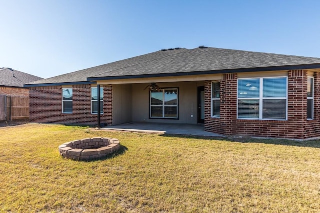 back of house with a fire pit, a patio area, and a yard