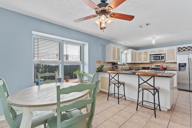 kitchen with pendant lighting, sink, backsplash, stainless steel appliances, and white cabinets