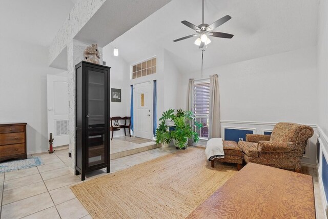 living area with ceiling fan, light tile patterned floors, and high vaulted ceiling