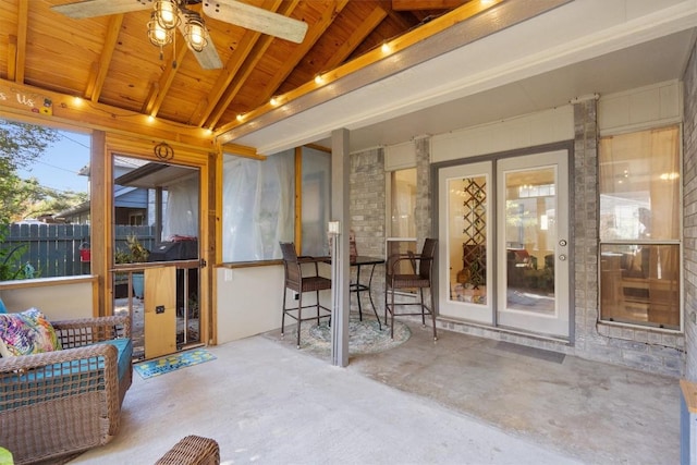 sunroom with ceiling fan, wooden ceiling, and lofted ceiling with beams