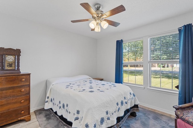 bedroom featuring ceiling fan, multiple windows, and light wood-type flooring