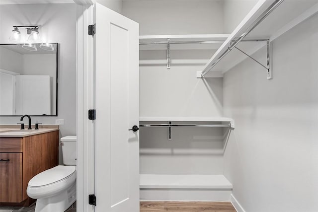 bathroom with hardwood / wood-style floors, vanity, and toilet