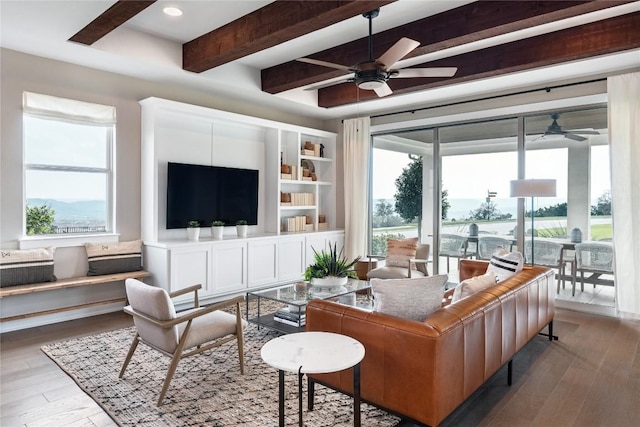 living room featuring wood-type flooring, ceiling fan, and beam ceiling