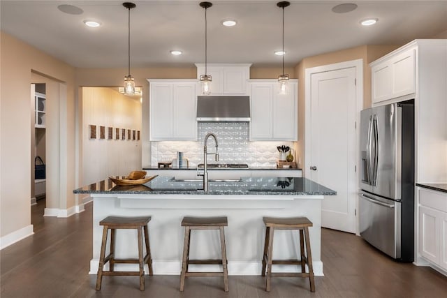 kitchen featuring stainless steel fridge with ice dispenser, dark hardwood / wood-style floors, an island with sink, decorative light fixtures, and white cabinets