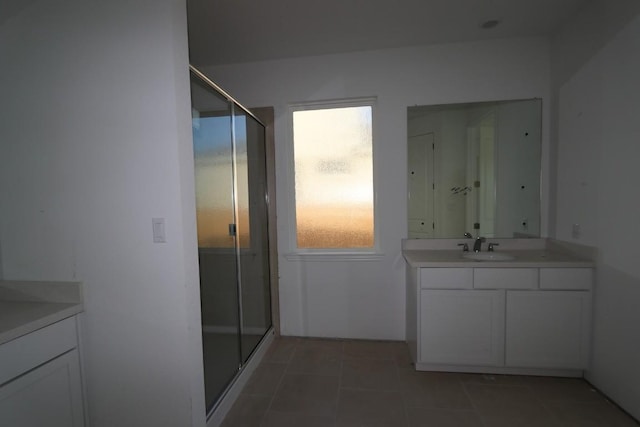 bathroom featuring tile patterned floors, vanity, and a shower with shower door