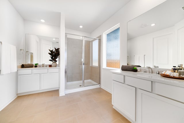 full bathroom featuring tile patterned floors, two vanities, a stall shower, and a sink