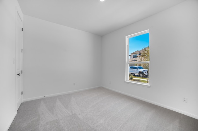 unfurnished room featuring baseboards and carpet