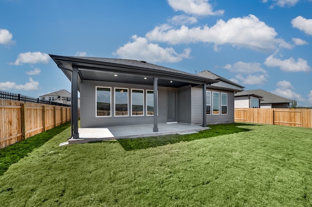 rear view of house with a patio area, a lawn, and a fenced backyard