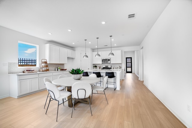 dining area featuring recessed lighting, visible vents, and light wood finished floors