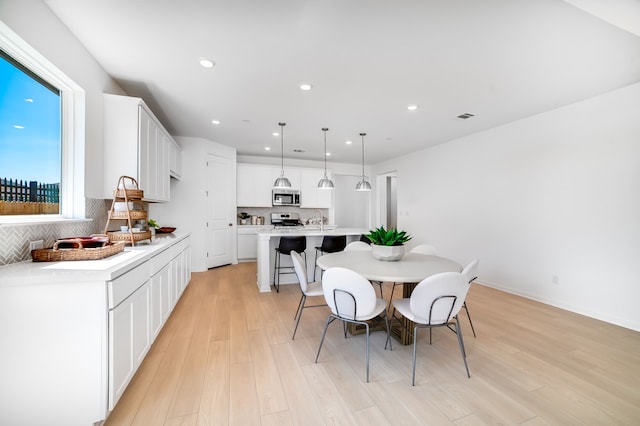 dining area featuring visible vents, recessed lighting, and light wood-type flooring