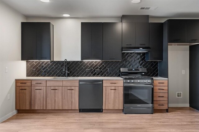 kitchen with light brown cabinets, backsplash, sink, light wood-type flooring, and appliances with stainless steel finishes