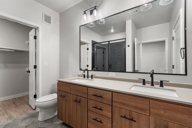 bathroom featuring walk in shower, toilet, vanity, and hardwood / wood-style flooring