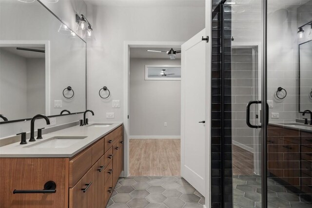 bathroom with walk in shower, ceiling fan, vanity, and hardwood / wood-style flooring