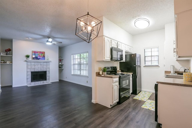 kitchen featuring pendant lighting, dark wood-type flooring, black appliances, sink, and white cabinetry