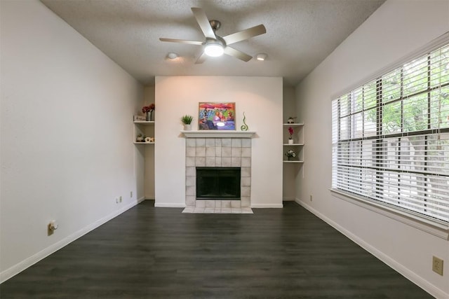 unfurnished living room featuring a textured ceiling, a tile fireplace, ceiling fan, and dark hardwood / wood-style floors