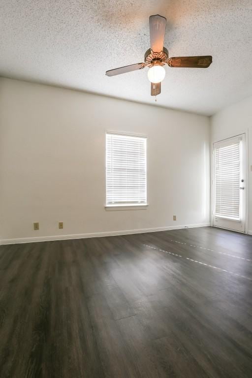 empty room featuring a textured ceiling and dark wood-type flooring