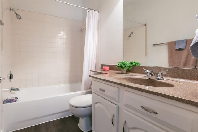 full bathroom with hardwood / wood-style floors, vanity, shower / tub combo, and toilet