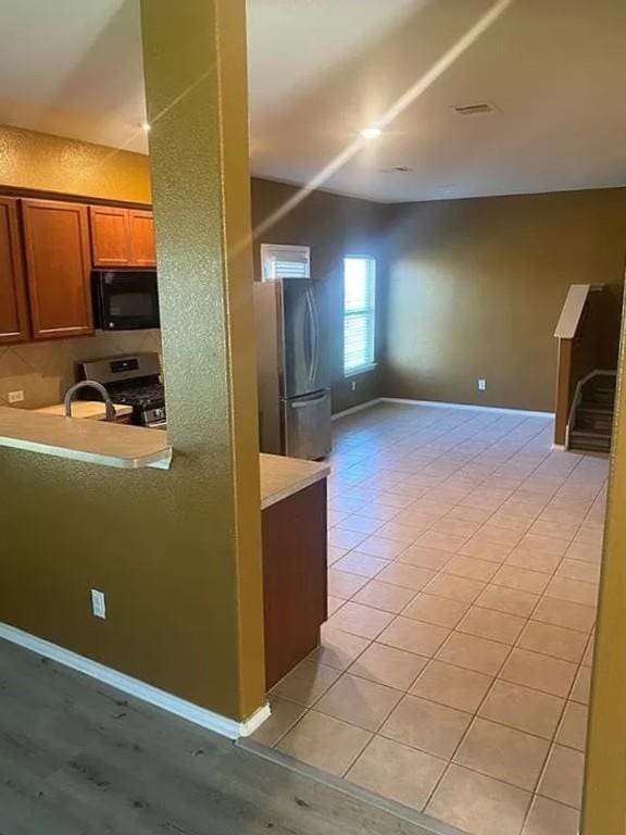 kitchen with sink, light tile patterned floors, and stainless steel appliances