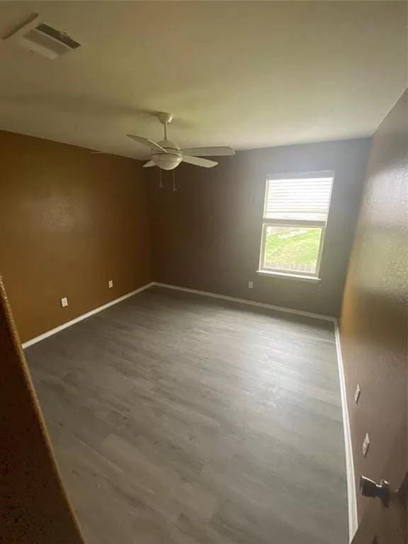 unfurnished room featuring dark hardwood / wood-style floors and ceiling fan